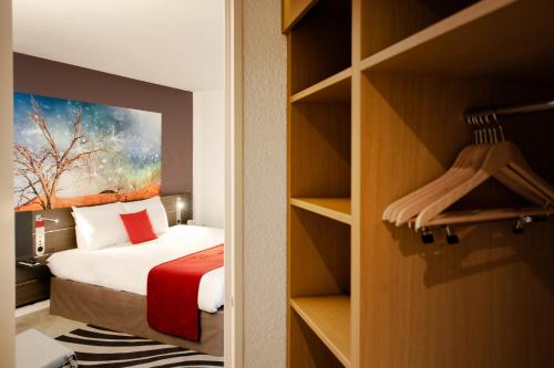 a hotel room with a bed and a closet at Novotel Lyon Gerland Musée des Confluences in Lyon