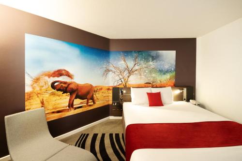a room with a bed and a painting of an elephant at Novotel Lyon Gerland Musée des Confluences in Lyon
