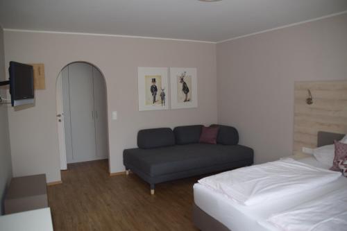 a living room with a couch and a bed at Seegasthof Breineder - Familien & Seminarhotel in Mönichwald