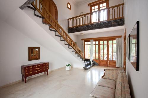 a living room with a couch and a staircase at Villa Sa Coma in Sa Coma