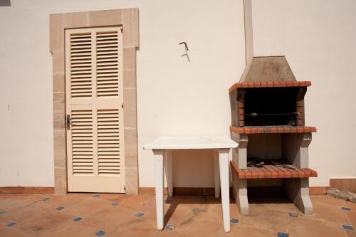 a room with a stove and a table and a door at Villa Sa Coma in Sa Coma