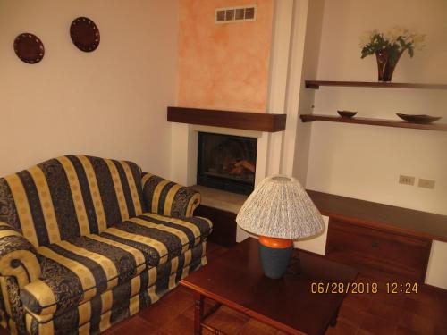a living room with a couch and a fireplace at 5 Palme in Terzo dʼ Aquiléia