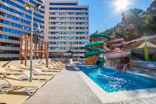 una piscina con sillas y un tobogán de agua en Magic Aqua Rock Gardens, en Benidorm