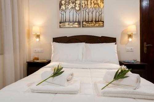 a white bed with towels and flowers on it at Villa Alexandra in Kissamos