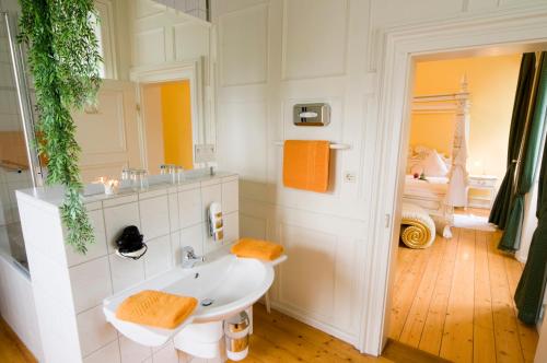 ein weißes Badezimmer mit einem Waschbecken und einem Spiegel in der Unterkunft SchlossHOTELGedern in Gedern