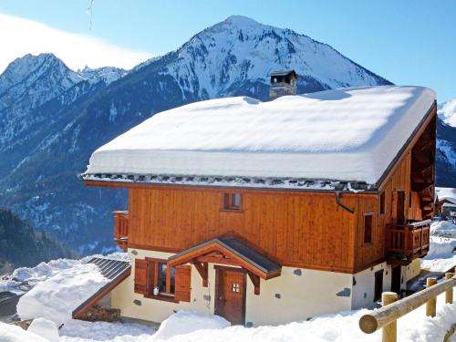 a building covered in snow with a mountain in the background at Chalet in Champagny en Vanoise with Vanoise summits in Le Villard