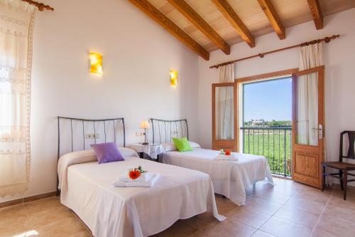 deux lits dans une chambre avec une grande fenêtre dans l'établissement Mussol, à Sa Pobla