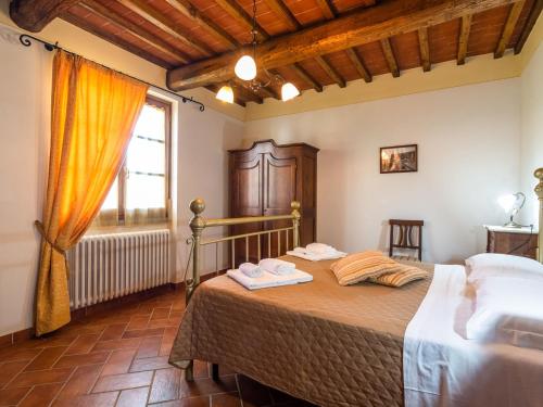 1 dormitorio con 1 cama en una habitación con ventana en Belvilla by OYO Agriturismo with garden, en Castiglion Fiorentino