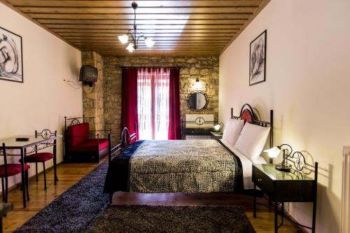 Schlafzimmer mit einem Bett und einem roten Fenster in der Unterkunft Village Inn in Ano Chora