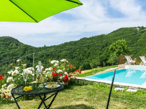 a table with flowers next to a swimming pool at Pretty Farmhouse with pool in Sestino