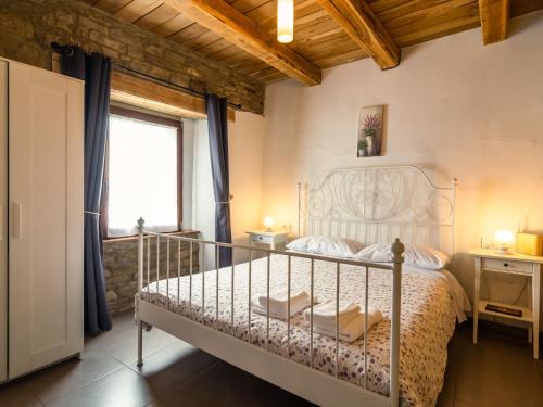 a bedroom with a white bed and a window at Pretty Farmhouse with pool in Sestino