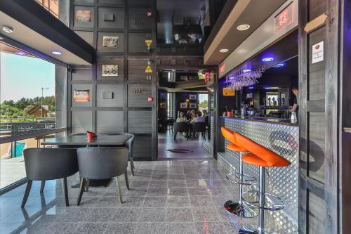 a bar with a table and chairs in a restaurant at Resort Hotel Elija in Šventoji