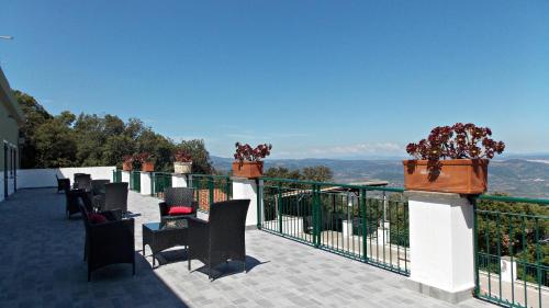 a balcony with chairs and a view of the mountains at S'Enis Monte Maccione in Oliena