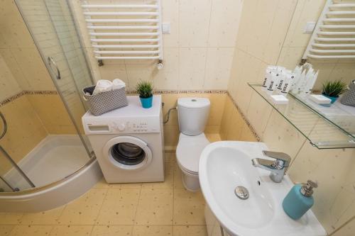 a bathroom with a toilet a sink and a washing machine at Blue Sky Apartment Warsaw in Warsaw