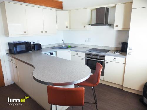 a kitchen with a counter and a table and chairs at Princes Dock Chambers 8 in Hull