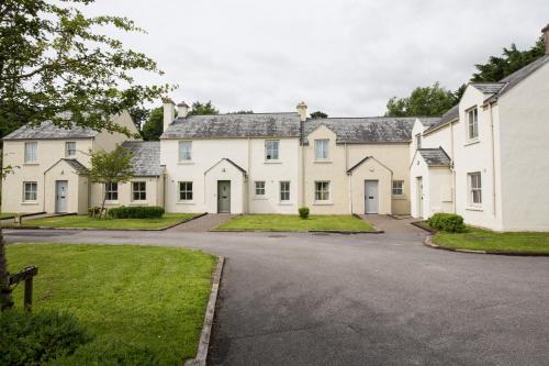 a row of white houses with a driveway at Bunratty Castle Gardens Home in Bunratty