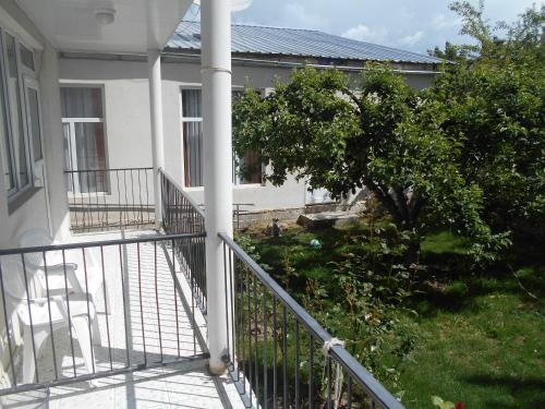a balcony of a house with a tree at Boomerang Guest house in Cholpon-Ata