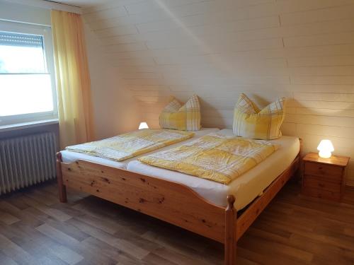 a bedroom with a bed with two pillows and a window at Dat Inselhuus in Norden