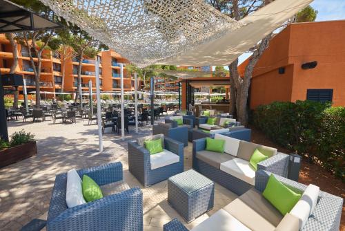 an outdoor patio with couches and tables and chairs at Protur Turo Pins 4* SUP in Cala Ratjada