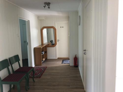 a hallway with a table and a chair and a mirror at Åndalsnes gustehouse in Åndalsnes