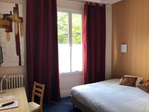 um quarto com uma cama e uma janela com cortinas vermelhas em Hôtel Villa Du Parc em Nevers
