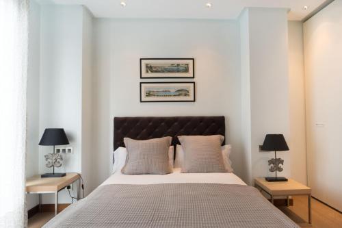 1 dormitorio con 1 cama grande y 2 mesitas de noche en Niza La Concha - IB. Apartments, en San Sebastián