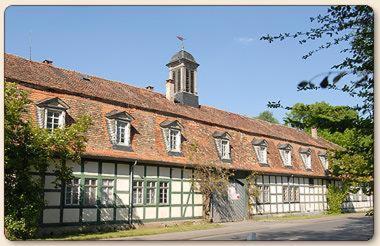 a large brick building with a clock tower on top at Jagdschloss Mönchbruch in Mörfelden-Walldorf