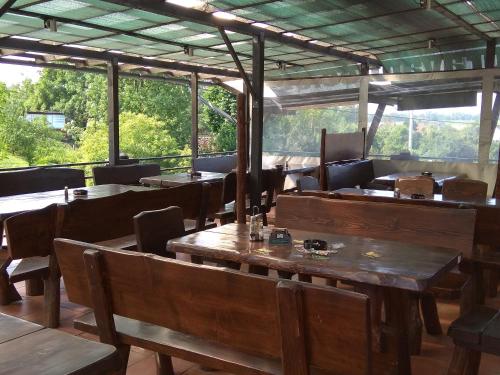 un restaurante con mesas y sillas de madera y ventanas en Penzion a Motobar Bravantice en Bravantice