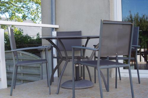 deux chaises et une table sur une terrasse dans l'établissement Chambres d'hôtes du Theven, à Plougoulm