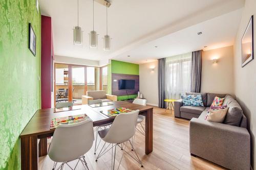 a kitchen and living room with a table and chairs at Wczasowa, Sun & Snow in Ustka