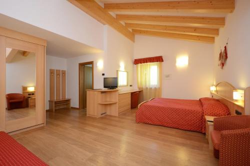 a hotel room with two beds and a television at Hotel La Soldanella in Moena