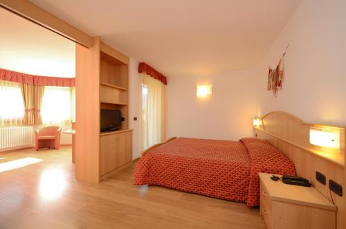 a hotel room with a bed and a television at Hotel La Soldanella in Moena