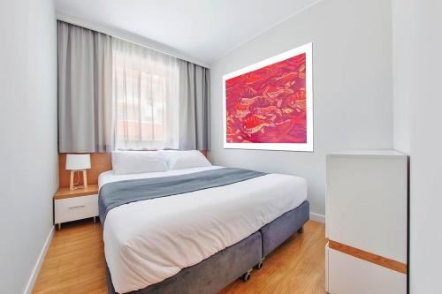 a bedroom with a bed and a painting on the wall at Wczasowa, Sun & Snow in Ustka