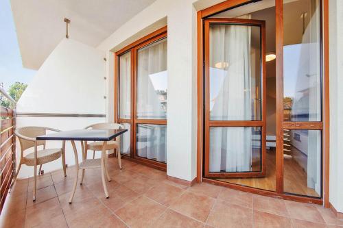 a dining room with a table and chairs and windows at Wczasowa, Sun & Snow in Ustka