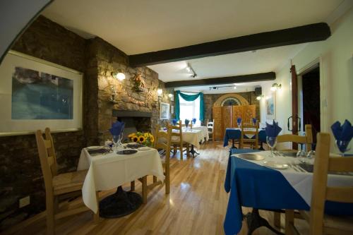 a dining room with tables and chairs and a fireplace at Cwmwennol Country House in Saundersfoot