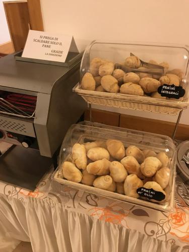 two trays of buns are sitting next to a printer at Hotel Il Pino in San Vincenzo