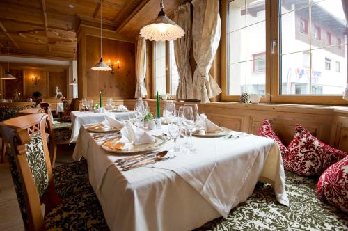 a dining room with tables with white tablecloths at Alpenresort Fluchthorn in Galtür
