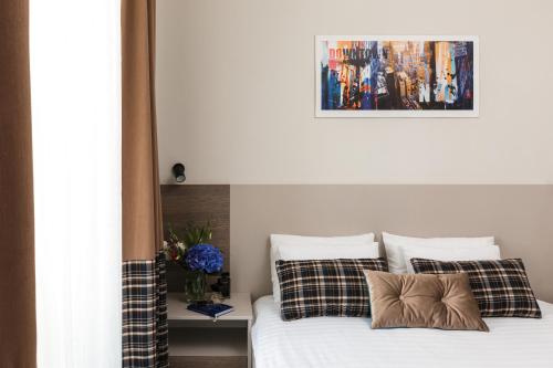 a bedroom with a bed with a picture on the wall at Deribas Hotel in Odesa