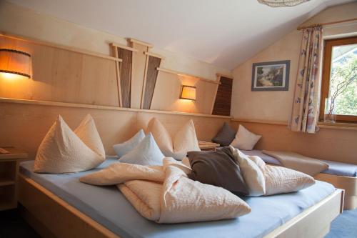 a bed with pillows on it in a room at Haus Wulfenia in Neustift im Stubaital