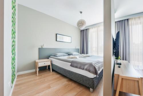 a bedroom with a large bed and a desk at Wczasowa, Sun & Snow in Ustka
