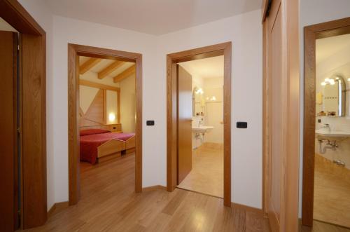 a room with a bedroom and a bed and two doors at Hotel La Soldanella in Moena