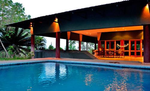 a house with a swimming pool in front of it at Tingala Lodge - Bed in the Bush in Phalaborwa