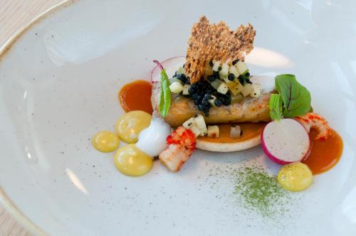 a plate of food with fish and vegetables on it at Apartamenty Mesa Grill Restaurant Cafe in Dźwirzyno