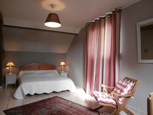 1 dormitorio con 1 cama y 1 silla junto a una ventana en Le Cardonnet, en Pont-Saint-Pierre