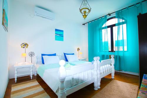 1 dormitorio con 1 cama blanca y paredes azules en Villa Nena, en Herceg-Novi