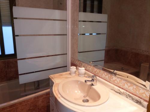 a bathroom with a sink and a mirror at Casa El Reloj in Mombeltrán