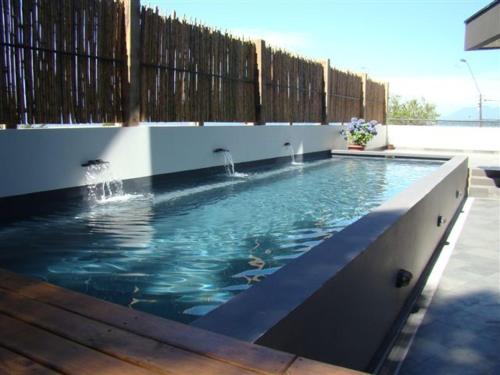a large swimming pool with a wooden fence at Hotel Terraza Suite in Villarrica