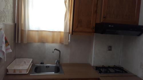 eine Küchentheke mit einem Waschbecken und einem Fenster in der Unterkunft Mountain Vista Resort in Roústika