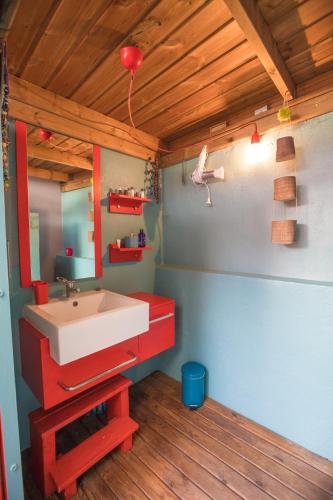 a bathroom with a red sink and a mirror at Villa Yapaplupres in Saint-Leu