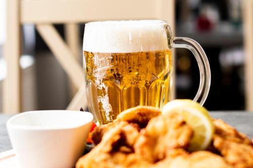 a glass of beer and some onion rings and a mug at Penzion Šafrán in Jeseník